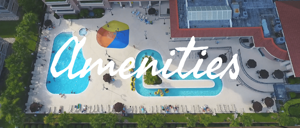 An aerial view of the hotel's pool area with a large pool, lounge chairs, and umbrellas.